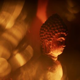 A peaceful Buddha statue illuminated by warm, golden light, exuding spirituality.