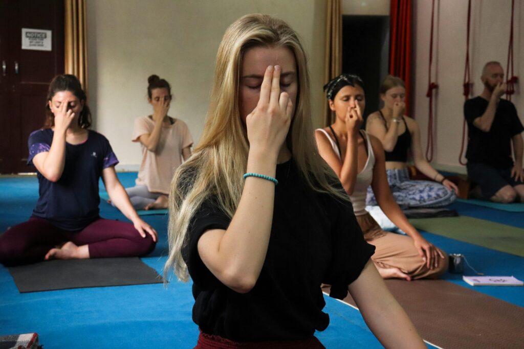 Yoga students practicing meditation in Rishikesh, India, focusing on breathing exercises for relaxation.