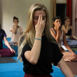 Yoga students practicing meditation in Rishikesh, India, focusing on breathing exercises for relaxation.